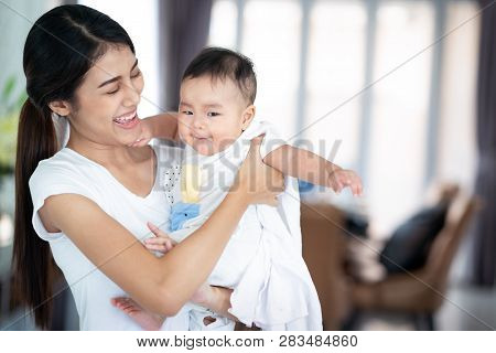 Asian Mother And Her Baby Play Togather In The Family Room