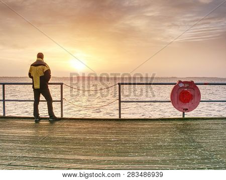 Man Tourist In Autumn Mist On Wooden Pier Above Sea. Depression Dark Atmosphere.
