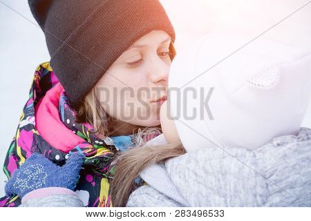 Happy Mother Kising Baby Girl In The Winter Park