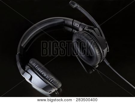 Black Wired High-fidelity Headset With Full Size Headphones Close-up On A Dark Reflected Surface