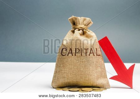 Money Bag With The Word Capital And Arrow To Down. Capital Outflow. Currency Devaluation. Falling St