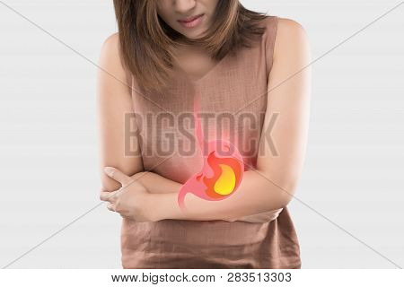 Acid Reflux Or Heartburn, The Photo Of Stomach Is On The Woman's Body Against Gray Background, Bad H