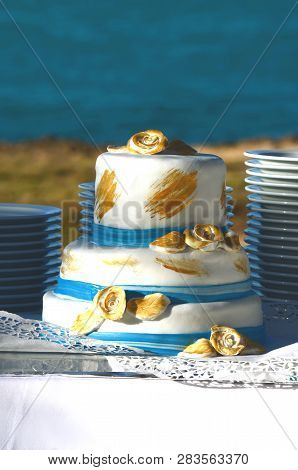Blue And Gold Wedding Cake In A Seaside Tropical Garden At A Destination Wedding Reception. Decorate