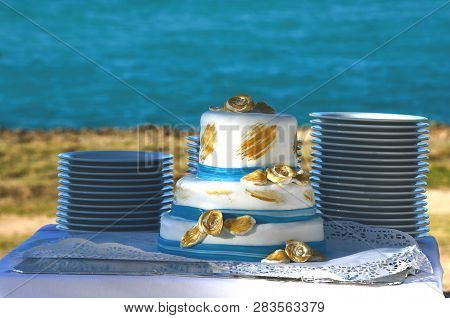 Blue And Gold Wedding Cake In A Seaside Tropical Garden At A Destination Wedding Reception. Decorate