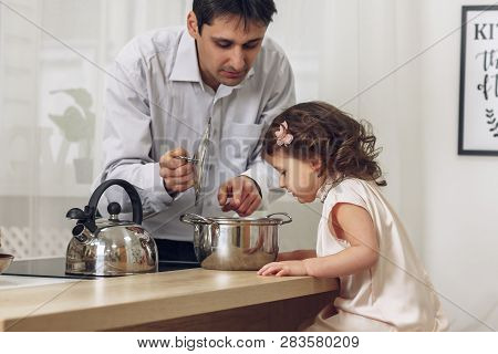 Daughter 3 Years Old With Father Cooking Dinner In The Kitchen