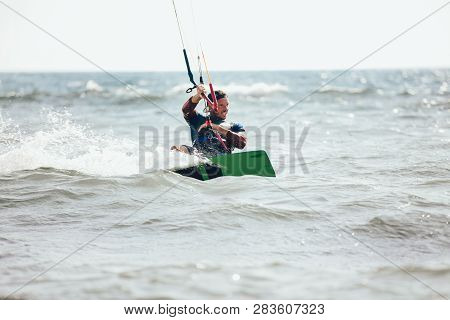 Professional Kiter Makes The Difficult Trick On A Beautiful Background. Kitesurfing Kiteboarding Act