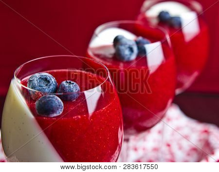 A Tasty Panna Cotta Dessert Of Strawberry Mousse And Cream Served In Wine Glasses. Red And White Dia