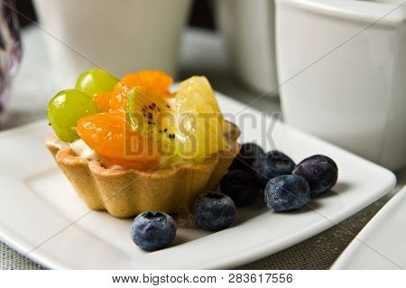 Still Life Composition Of A Delicious Fruit Cake With Coffee On The Table.