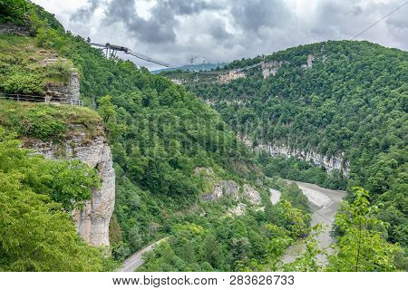 Skybridge Suspension Bridge Over A Precipice And River On A Cloudy Day. Skypark, Sochi, Russia.