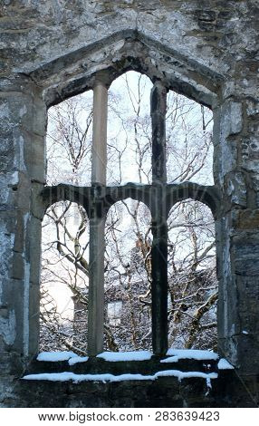 View Through A Window Of A Medieval Ruined Church In Heptonstall Yorkshire With Snow Covered Trees B