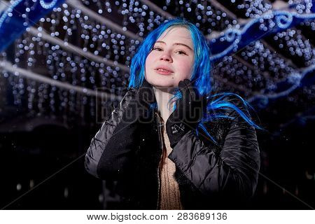 Portrait Of Girl With Blut Hair Skating On The Ice Arena In The Evening City Square In Winter