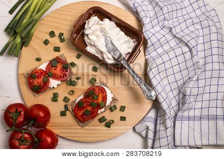 Healthy And Vegetarian Breakfast With Crispbread, Quark, Tomatoes And Spring Onions On A Wooden Boar