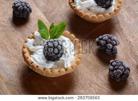 Delicious Tartlets On A Wooden Background. Blackberry With Cream - Dessert.healthy Homemade Berry De