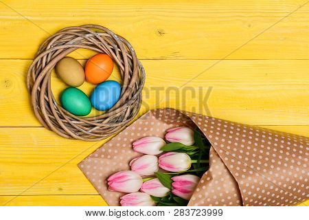 Collecting Easter Eggs. Spring Vibes. Colorful Eggs And Bouquet Fresh Tulip Flowers On Yellow Backgr