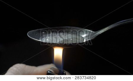 Cooking Heroin On Spoon Close Up On Candle. A Close Up View Of A Spoon Cooking Heroin
