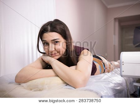 Cosmetology Beauty Clinic. Young Woman Taking Myostimulation, Smiling And Looking At The Camera At T