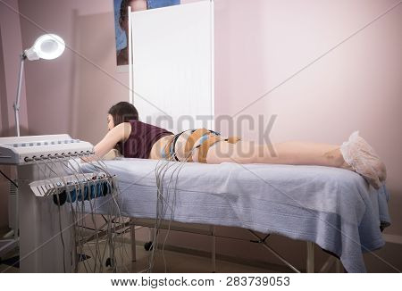 Young Woman With Dark Hair Taking Myostimulation At The Nutritionists Office