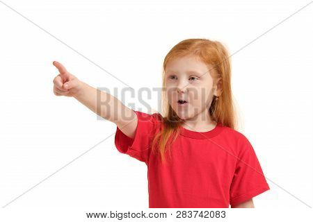 Education, School And Imaginary Screen Concept - Cute Little Girl Pointing In The Air Or Imaginary S