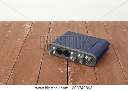 Music And Sound - Front View Interface Sound Card On A White And Wooden Background.