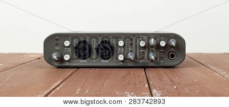 Music And Sound - Front View Interface Sound Card On A White And Wooden Background.
