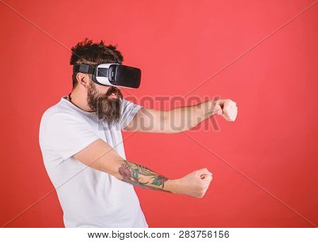 Man With Beard In Vr Glasses Driving Car, Red Background. Virtual Racing Concept. Guy Play Racing Ga