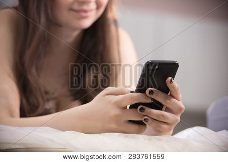 Close-up Of Woman Taking Myostimulation, Smiling And Looking At Her Phone Screen At The Nutritionist