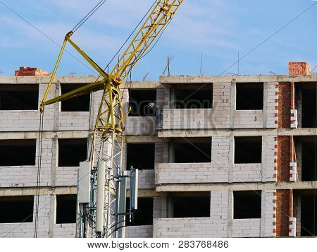 Concrete Building Under Construction. Crane Near Vuilding.