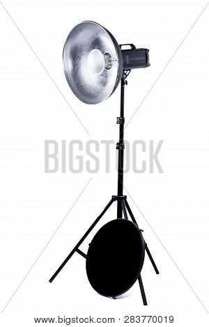 Studio Light Stand On White Background. Studio Monoblock Flash Light On Tripod. Camera Lighting With