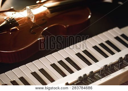Listening Classical Music. Close-up View Of Classical Violin Instrument Lying On A Synthesizer. Musi
