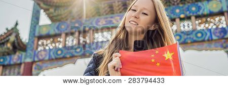 Enjoying Vacation In China. Young Woman With National Chinese Flag On The Background Of The Old Chin