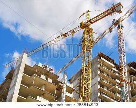 Construction Background. Construction Site With Cranes On Sky Background. Two Building Cranes And Bu