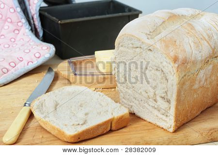 Um pedaço de lata de divisão de pão direto do forno, com crosta cortada. Manteiga, da forma 