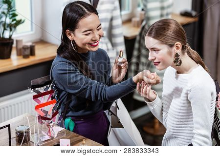Dark-haired Smiling Asian Woman In A Navy Polo Neck Looking Thoughtful