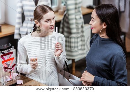 Dark-haired Smiling Asian Woman In A Navy Polo Neck And Her Friend Enjoying Their Time