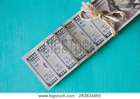 Paper Money 100 American Dollars Stacked In Line Tied Up Natural Flagella On Hand Painted Wood Green