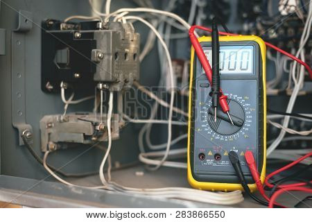 A Multimeter On A Electric Switchboard Background. Electric Work Concept Background.