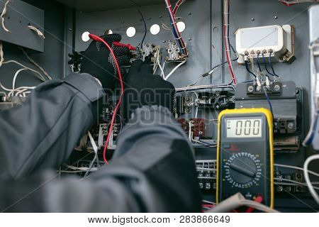 Electrician Is Checking The Voltage In The Electrical Circuit Of The Installation With A Multimeter 