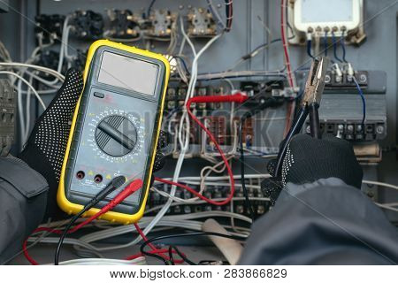 Electrician Is Checking The Voltage In The Electrical Circuit Of The Installation With A Multimeter.