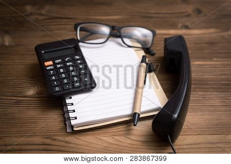Contact Us. Office Table Background. Blank Notepad With Copy Space For Text, Eyeglasses, Calculator 
