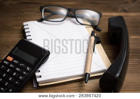 Contact Us. Office Table Background. Blank Notepad With Copy Space For Text, Eyeglasses, Calculator 