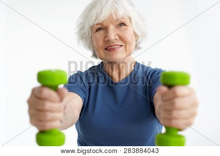 Cheerful Active Gray Haired Caucasian Female In Her Sixties Gaining Strength In Gym, Training With D