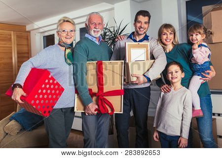 Grandmother And Grandfather Bring A Gift For Moving Into A New Apartment To Their Children