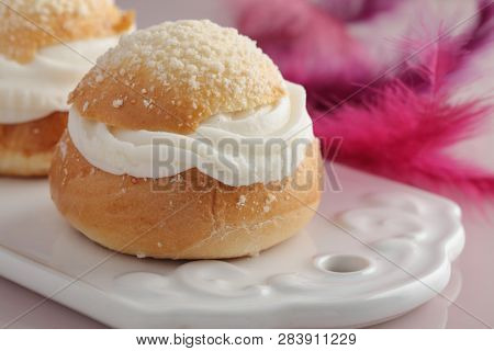 Fastelavn buns on a cutting board against Fastelavn decorations