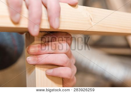 A Man Is Screwing A Screw Into A Wooden Table. Carpentry Workshop. Work With A Screwdriver.