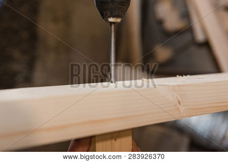A Man Is Screwing A Screw Into A Wooden Table. Carpentry Workshop. Work With A Screwdriver.