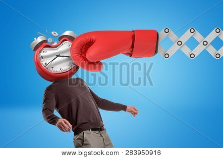 Huge Red Boxing Glove Punching Man With An Alarm Clock Instead Of His Face On Blue Background.