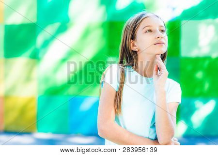 Teenage girl on the plaground background looking aside