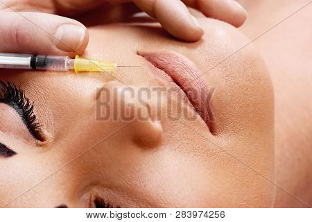 Injection Of Botox In Female Lips And Holding Syringe. Closeup Of Procedure To Lip Augmentation.  Co