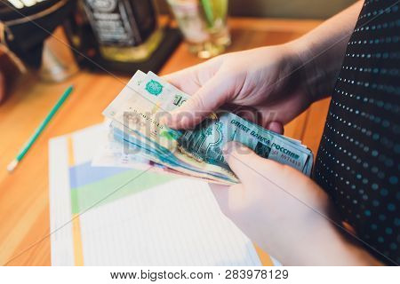 Russian Rubles In The Hand Of A Fan.male Hand Holding Many Of The Russian Banknotes.the Transfer Of 