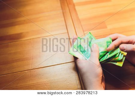 Russian Rubles In The Hand Of A Fan.male Hand Holding Many Of The Russian Banknotes.the Transfer Of 